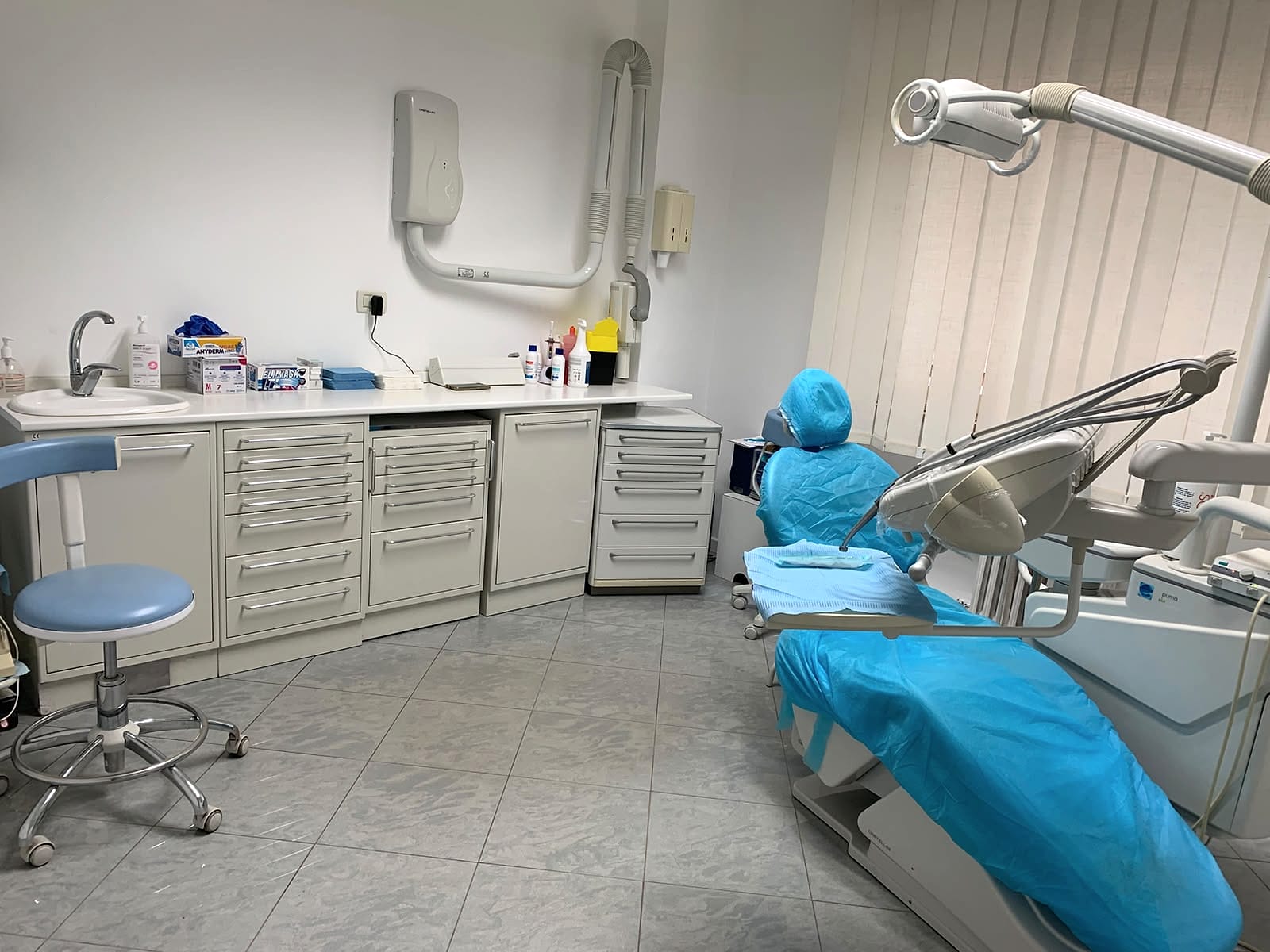 Sala operativa dello studio con poltrona odontoiatrica, mobili e lavabo
